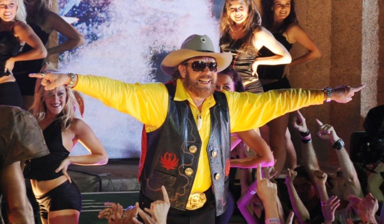 A man in a cowboy hat dancing with a woman in a yellow shirt