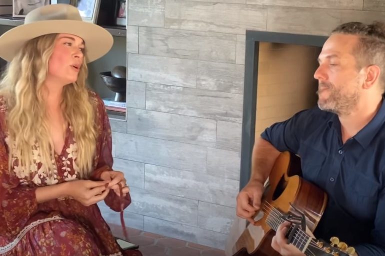 LeAnn Rimes playing a guitar next to a woman in a cowboy hat