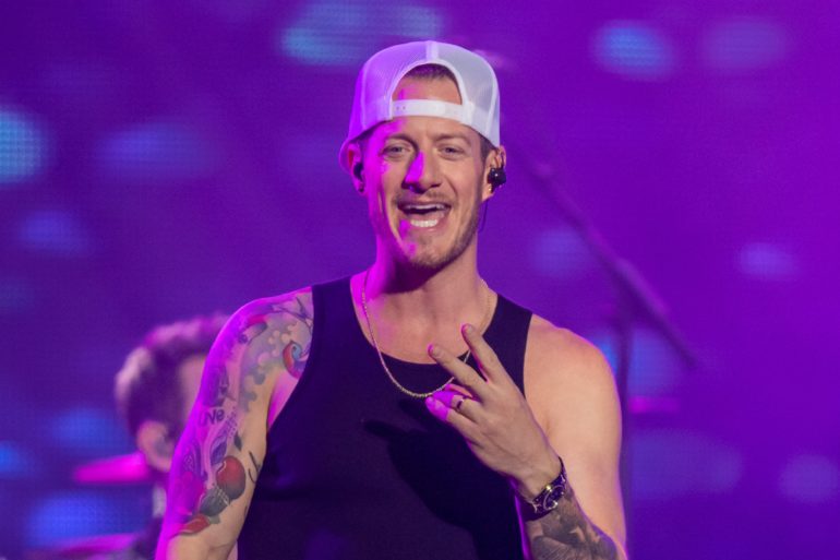 Tyler Hubbard with tattoos and a hat