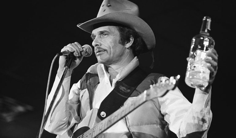 Merle Haggard holding a bottle of alcohol