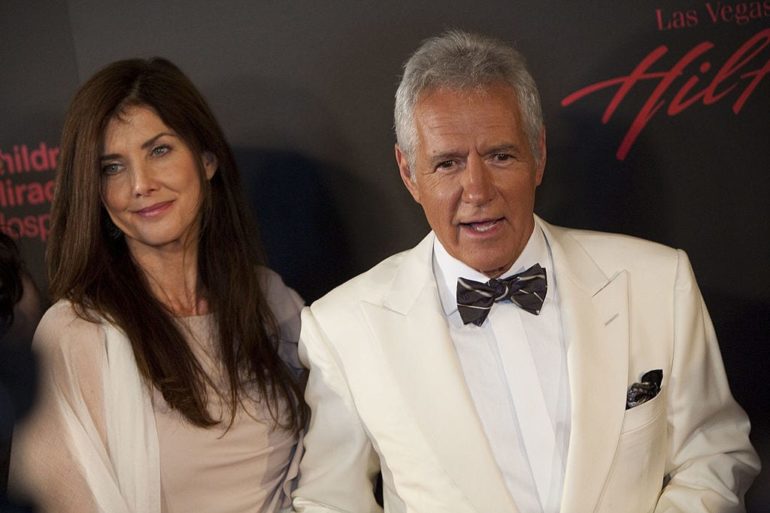 Alex Trebek and woman posing for a picture
