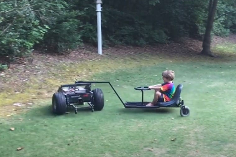 A child riding a lawn mower
