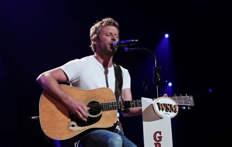 Dierks Bentley playing a guitar on a stage