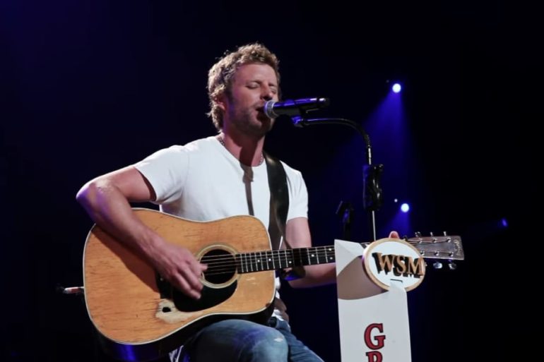 Dierks Bentley playing a guitar on a stage
