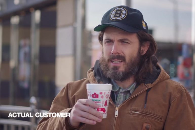 Casey Affleck wearing a hat and holding a cup