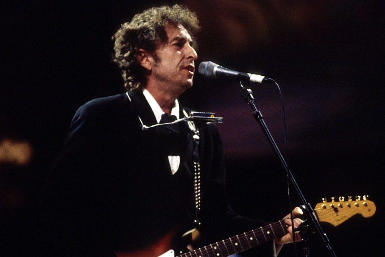 Bob Dylan playing a guitar