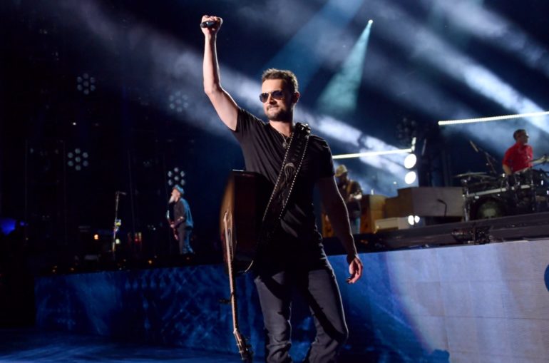 Eric Church holding a guitar and singing