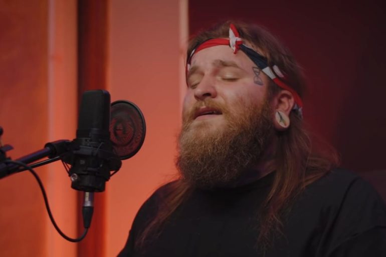 A man with a beard and a microphone in front of him