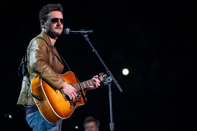 Eric Church playing a guitar on a stage