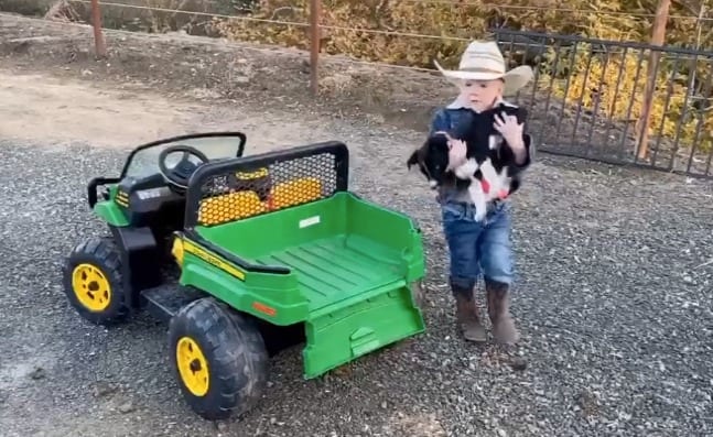 A child standing next to a tractor