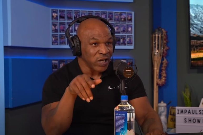 Mike Tyson wearing headphones and sitting at a desk