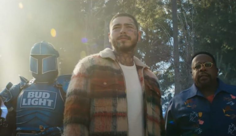 Post Malone standing next to a man in a garment