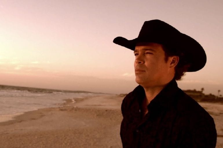A man wearing a hat and standing on a beach