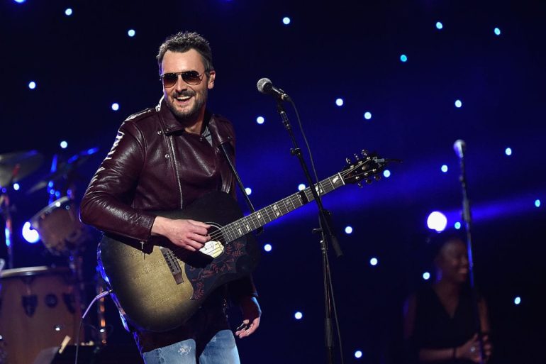 Eric Church playing a guitar on a stage