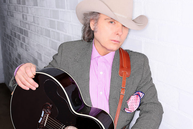 Dwight Yoakam wearing a hat and headphones