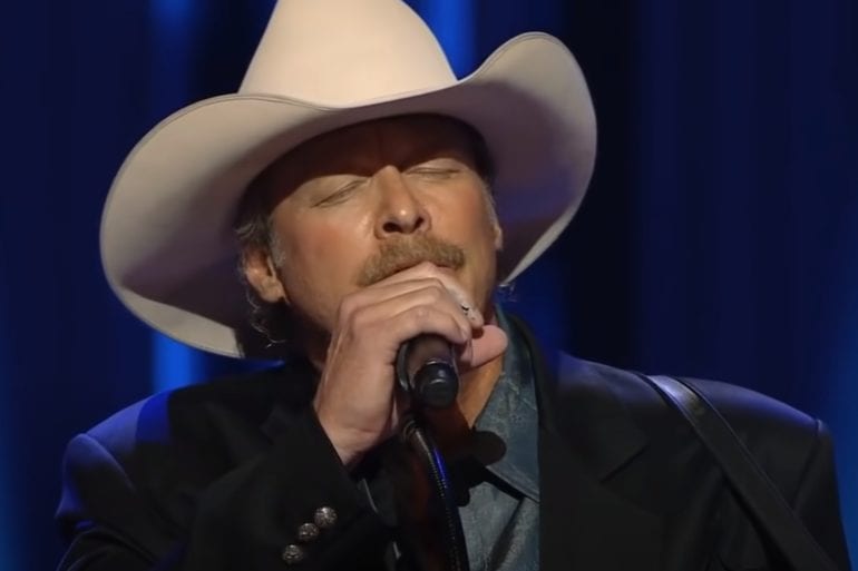 Alan Jackson wearing a hat and holding a cigarette to his mouth