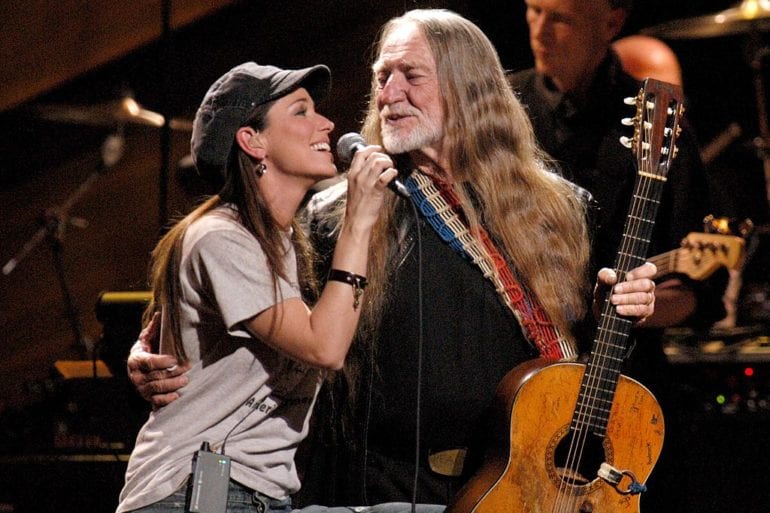 Willie Nelson and woman singing into a microphone