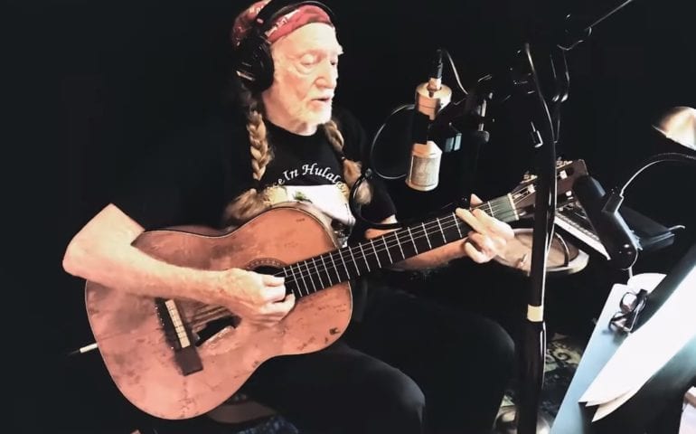 Willie Nelson playing a guitar