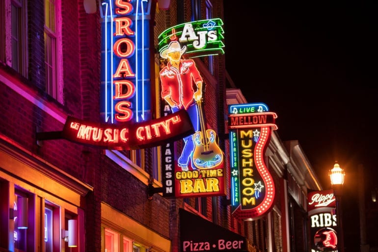 A city street with signs and neon signs