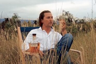 Matthew McConaughey sitting in a chair in a field of tall grass