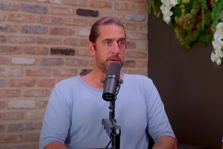 Aaron Rodgers speaking into a microphone