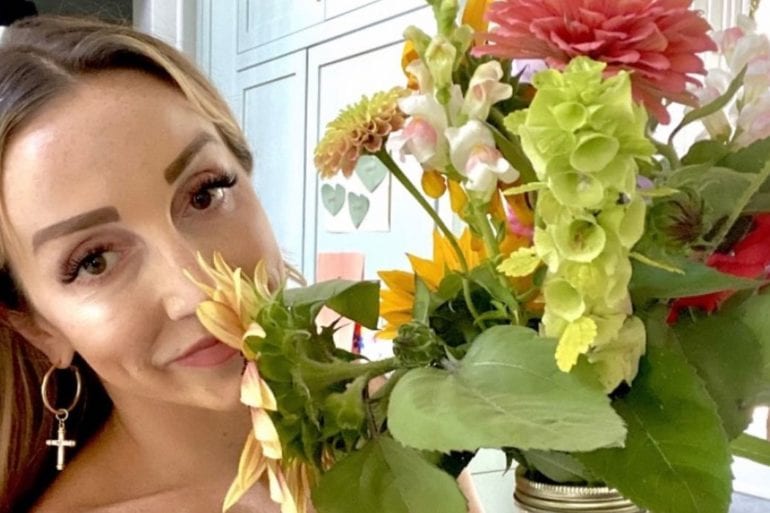 Ashley Monroe taking a selfie with a bouquet of flowers