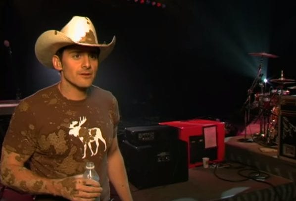Brad Paisley wearing a cowboy hat and playing a guitar