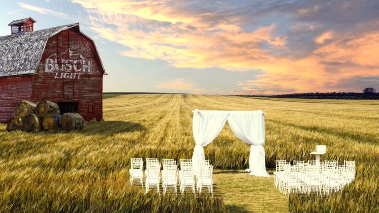 A field with a barn and a white picket fence in a field
