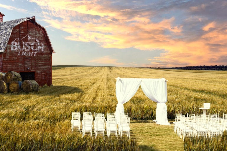 A field with a barn and a white picket fence in a field