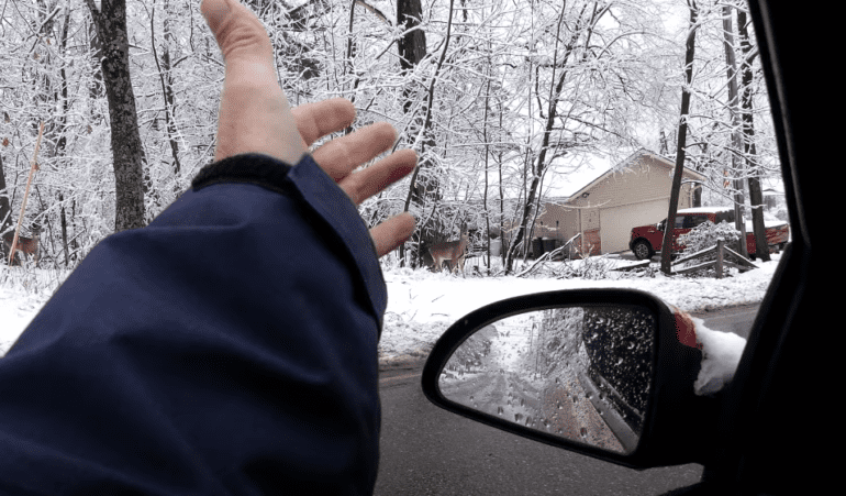 A person's hand outside a car window