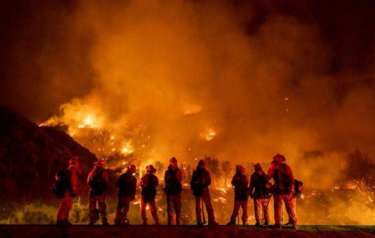 A group of people standing in front of a large fire