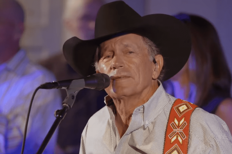 George Strait wearing a hat and a microphone