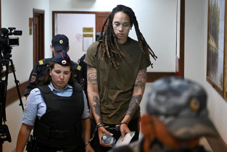Brittney Griner with a tattoo on her arm standing next to a man in a black shirt