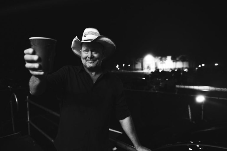 Tracy Lawrence holding a glass of beer