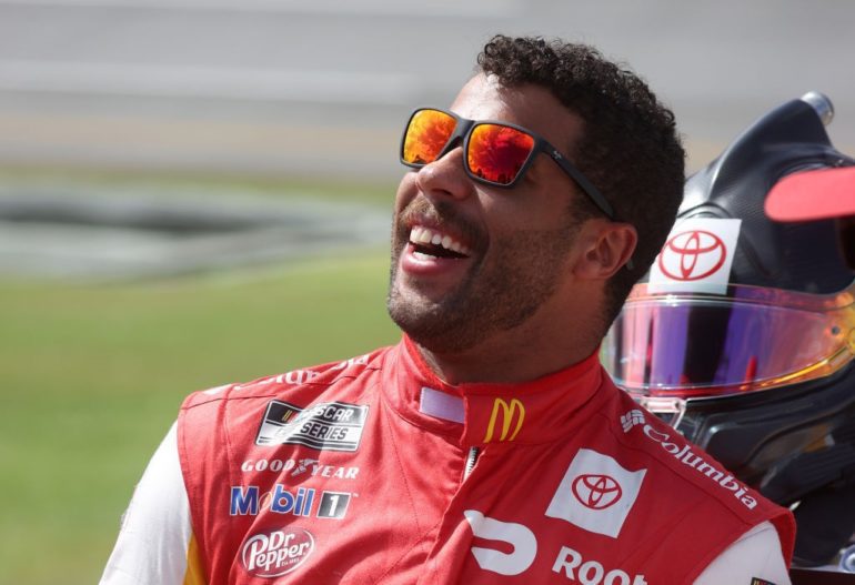 A man wearing sunglasses and a red and white racing helmet