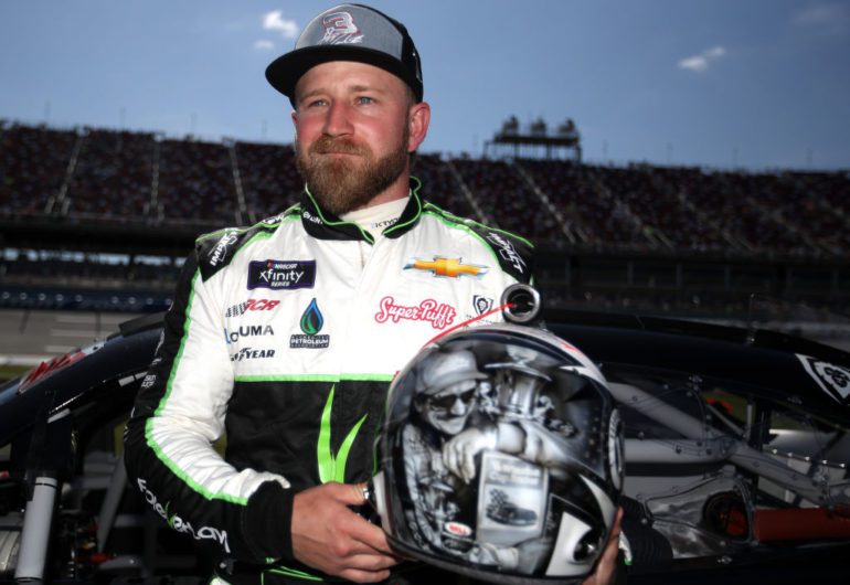 Jeffrey Earnhardt in a white and green uniform holding a helmet