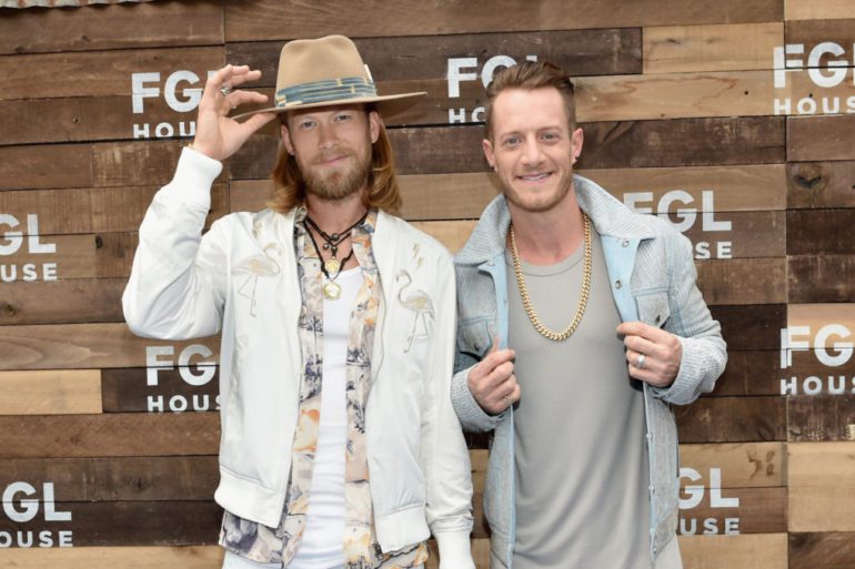 Tyler Hubbard, Brian Kelley are posing for a picture