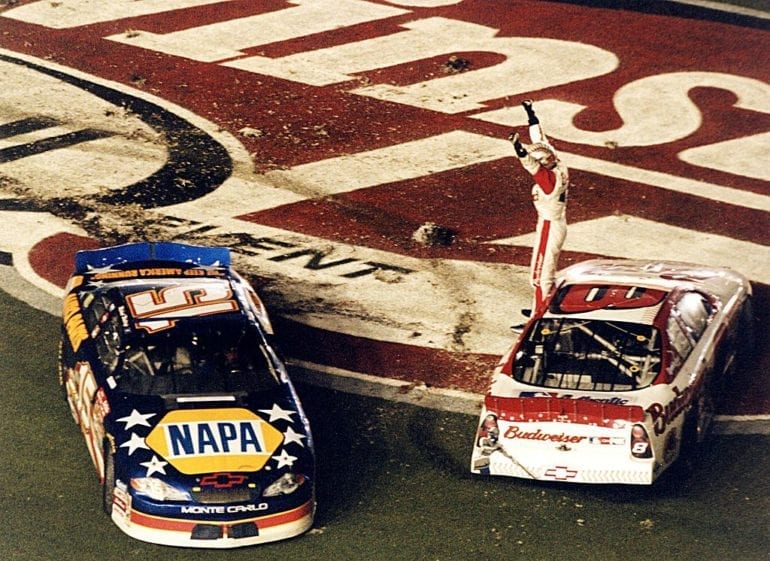 A person standing on top of a race car