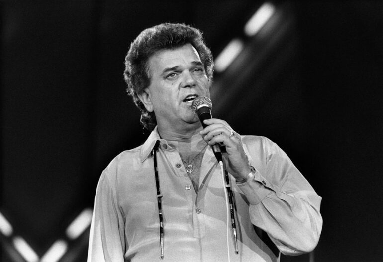 Conway Twitty holding a microphone