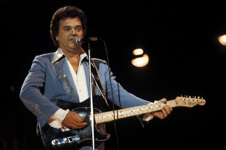 Conway Twitty playing a guitar