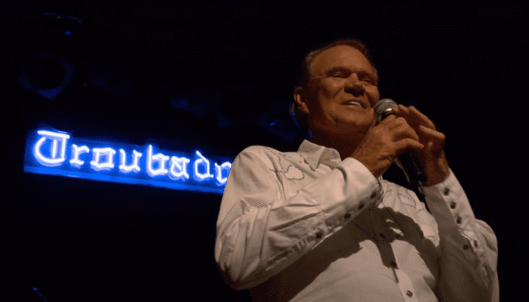 Glen Campbell holding a microphone