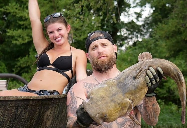 Brantley Gilbert and woman holding a large fish