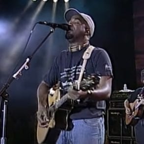 A person playing a guitar on a stage