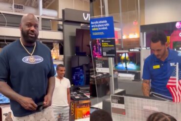 Shaquille O'Neal standing in front of a display of a sports team
