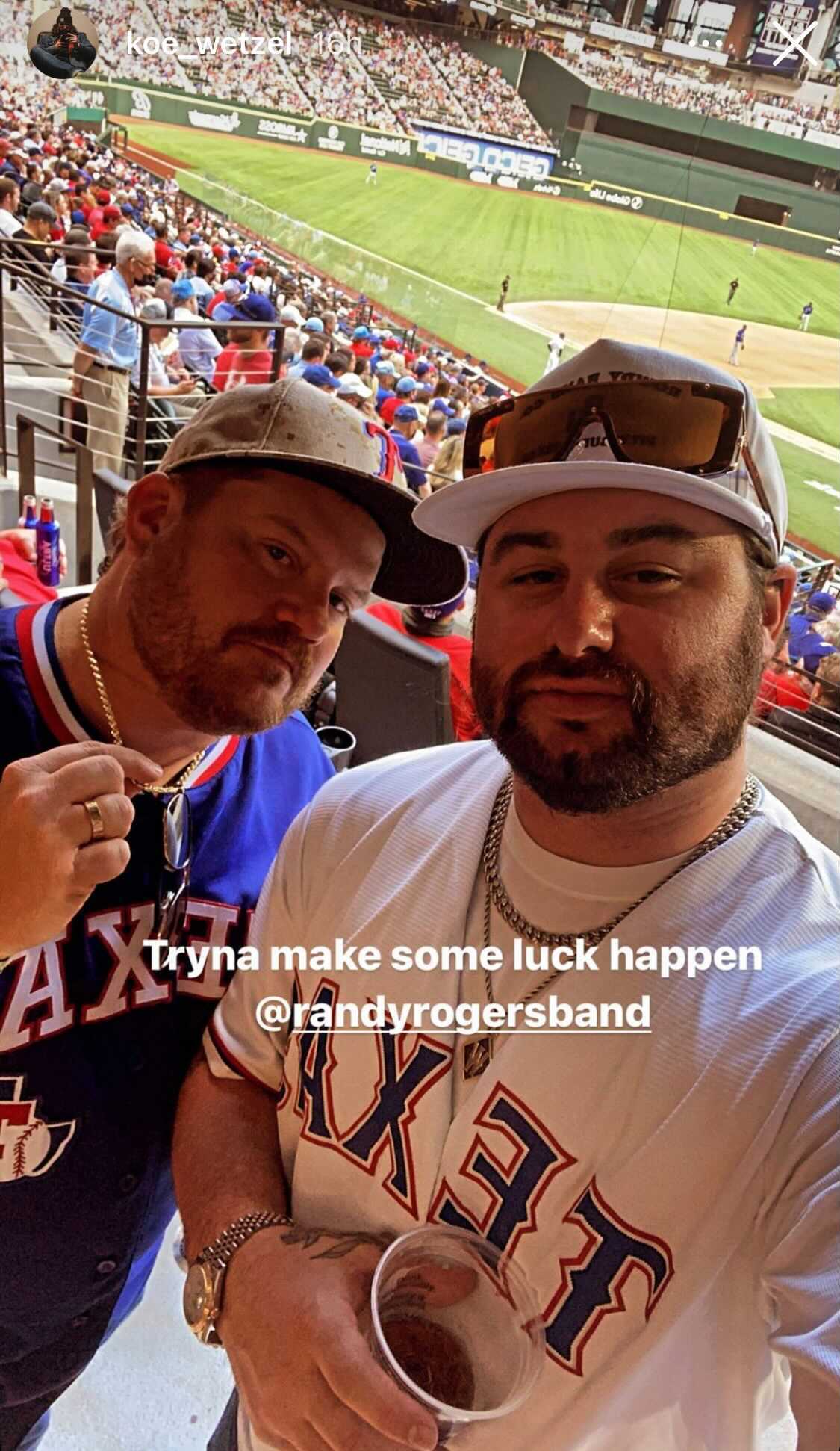 A couple of men posing for a picture at a baseball game