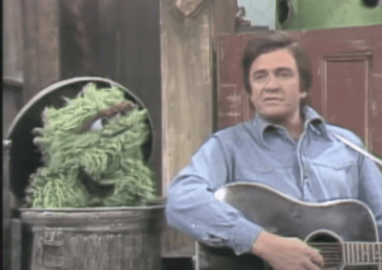Johnny Cash sitting in a chair with a green frog on his lap
