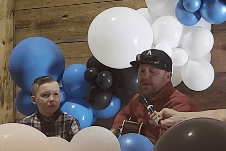 A person and a boy sitting in a room with balloons