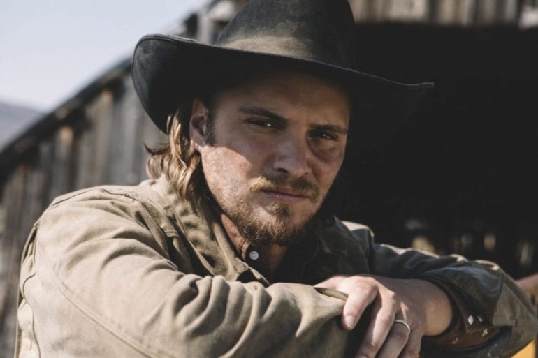Luke Grimes wearing a hat and a coat