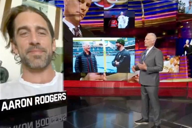 Aaron Rodgers standing in front of a television screen