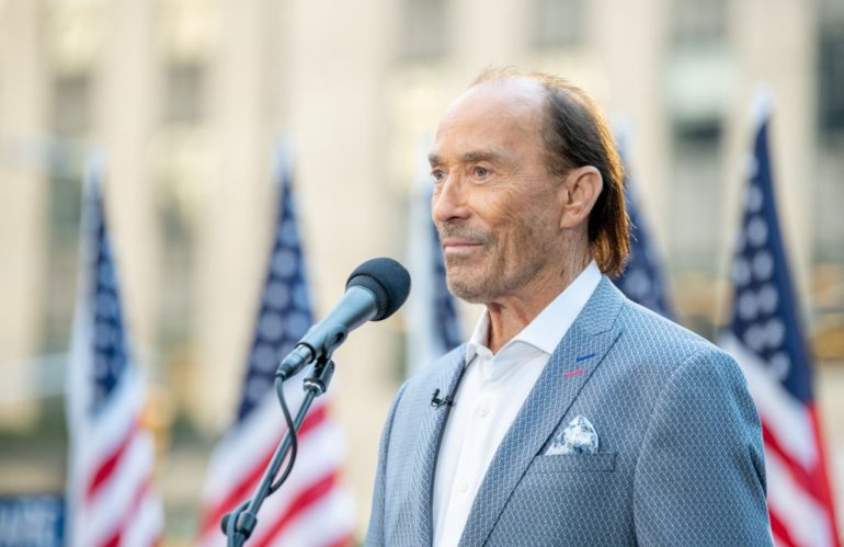 Lee Greenwood speaking into a microphone
